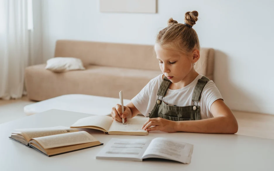 Kind im Kinderzimmer am Schreibtisch