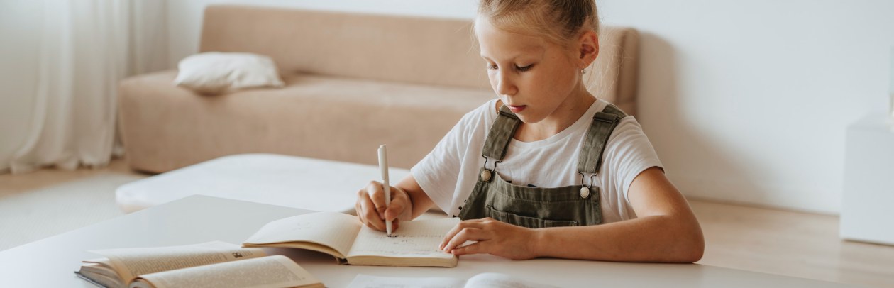 Kind im Kinderzimmer am Schreibtisch