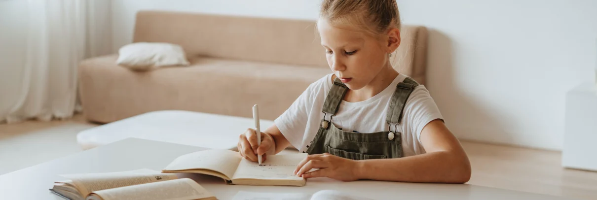 Kind im Kinderzimmer am Schreibtisch